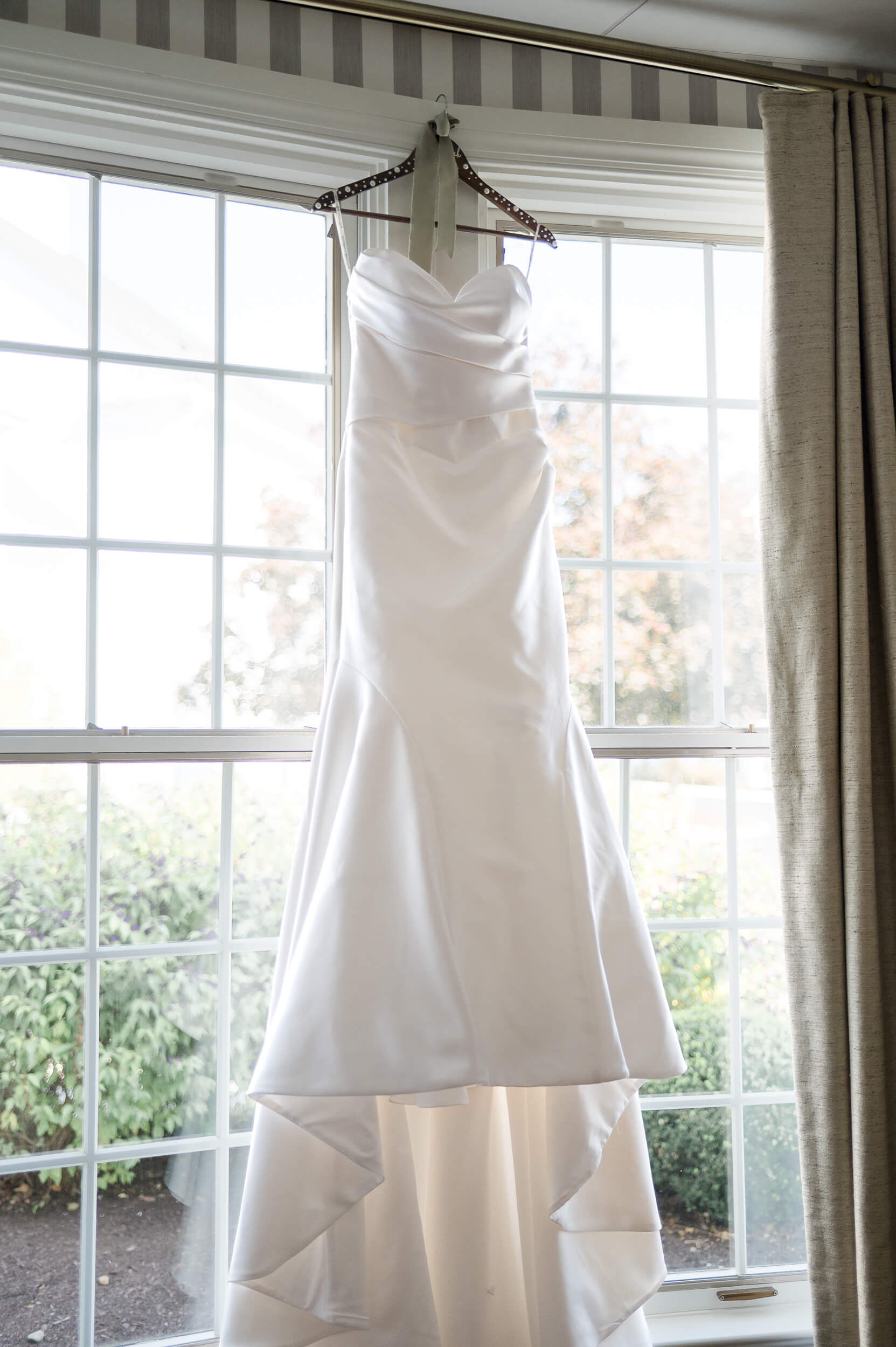 A bride's gown hangs in a bay window ready for eloping in Pennsylvania