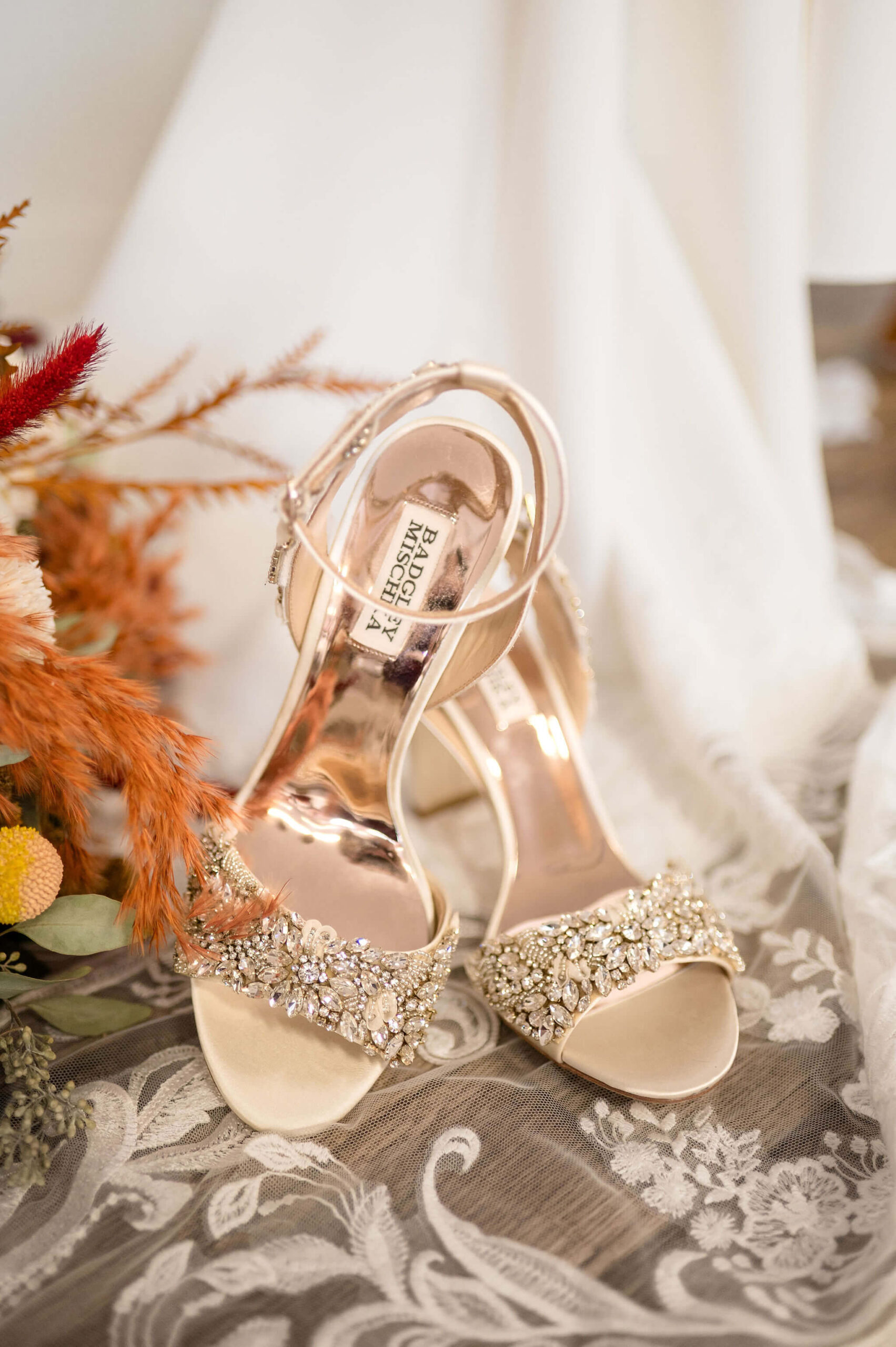 Details of a bride's diamond covered shoes on her lace embroidered veil at one of the Pennsylvania weddings