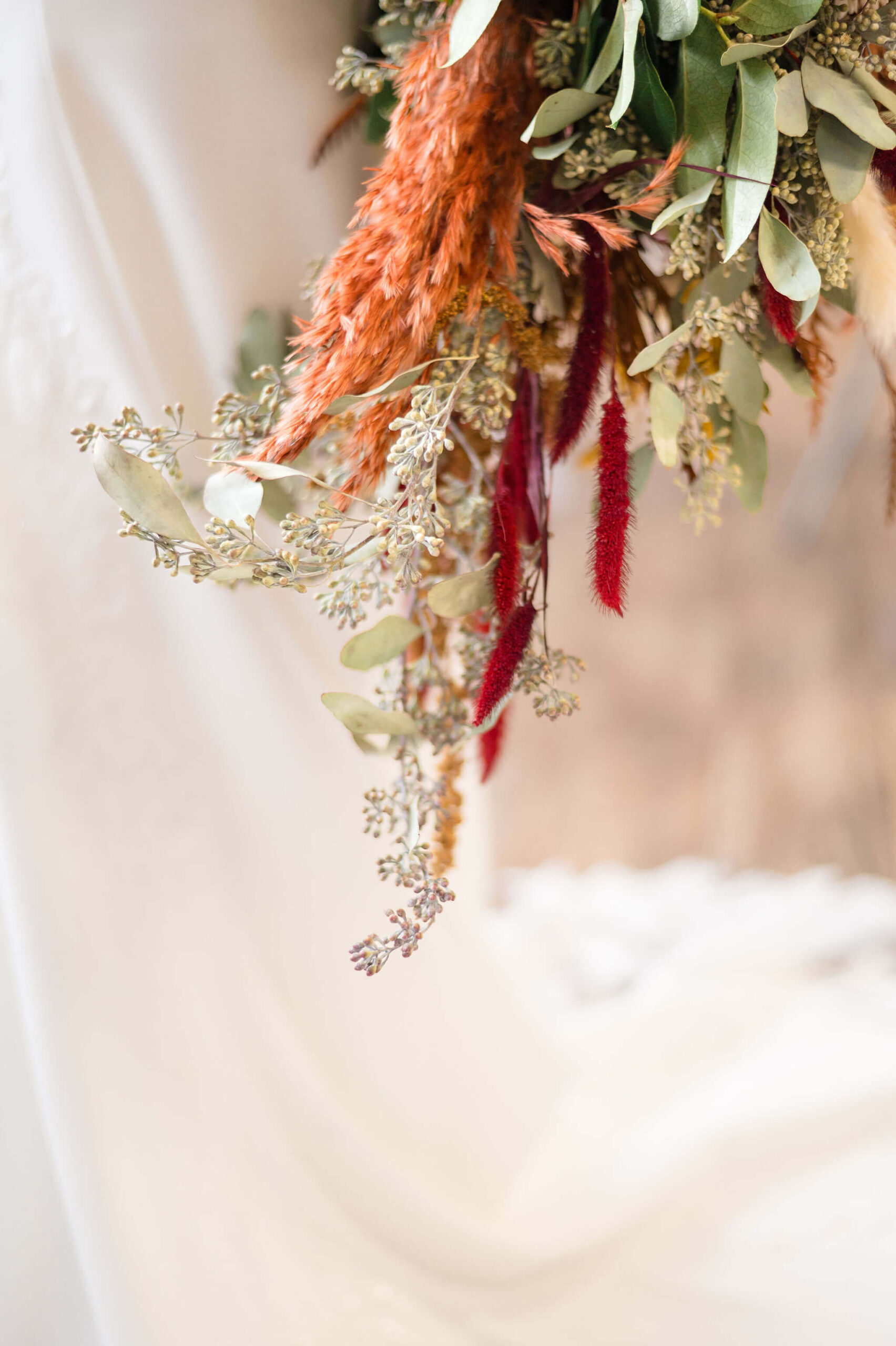 Details of a boho bouquet against a wedding gown at one of the Pennsylvania weddings