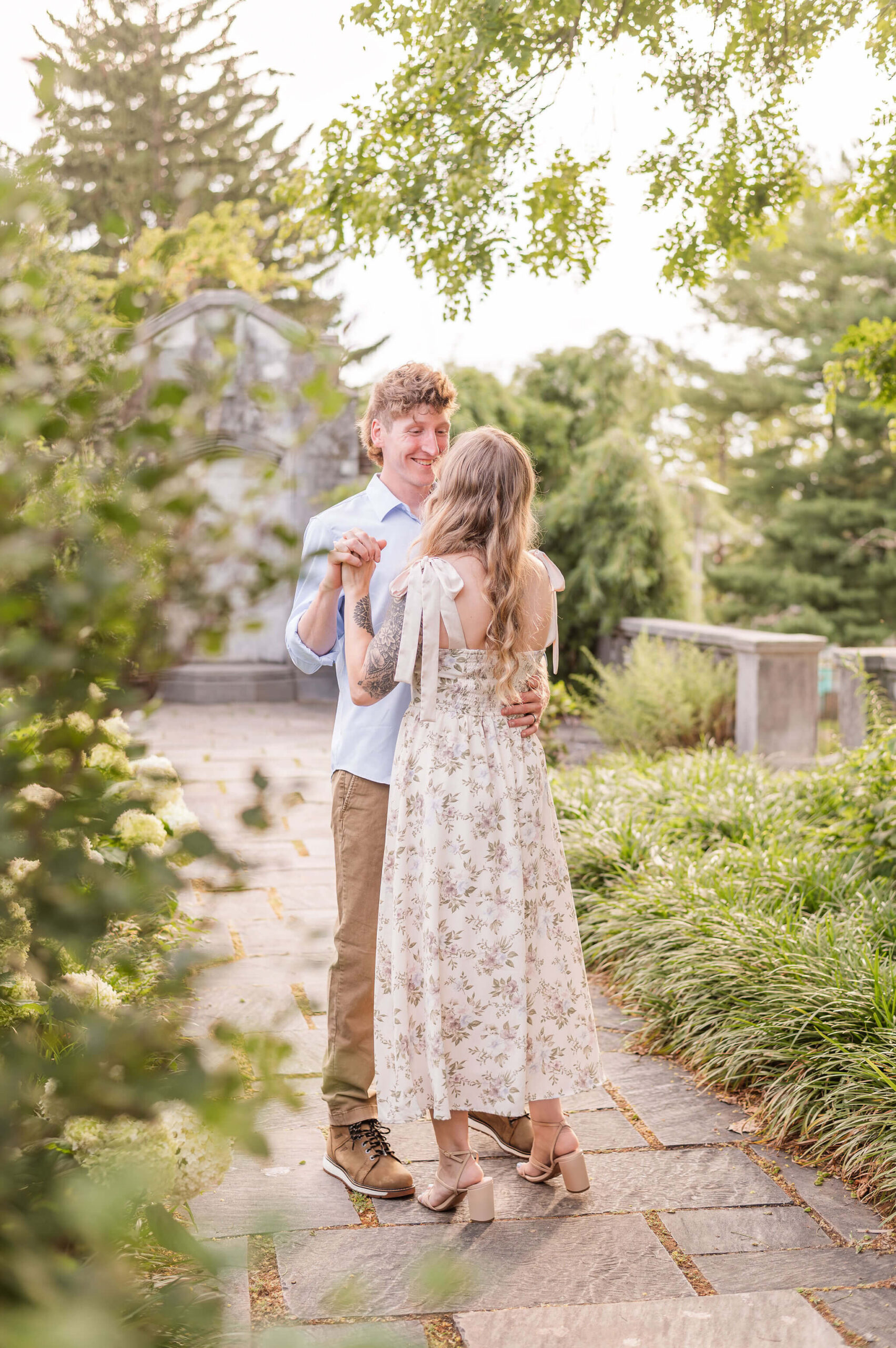 Couple dancing on garden pathway during engagement photos in Pittsburgh.