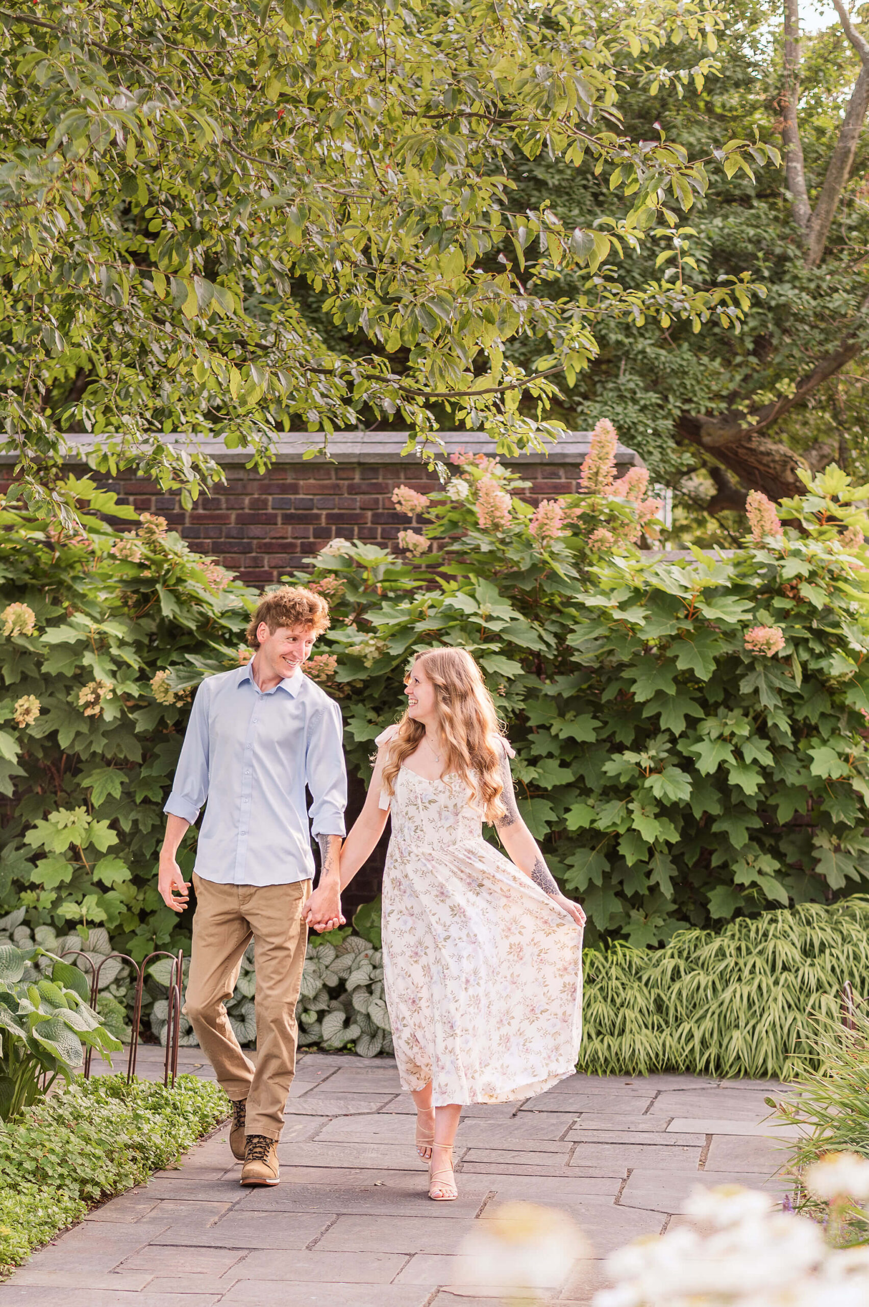 Couple walking hand in hand along stone path during engagement photos in Pittsburgh