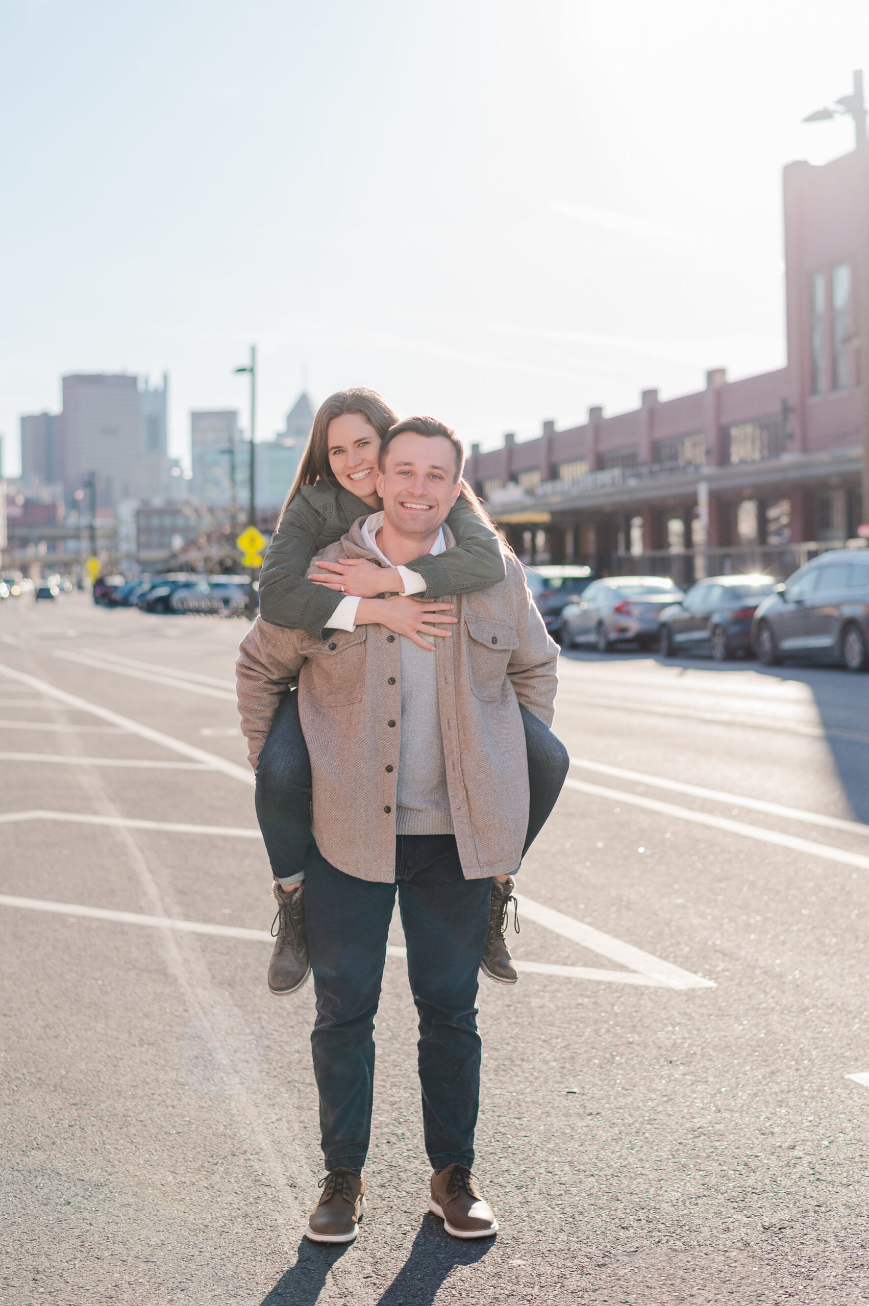 Groom lifting bride in a piggy-back position during their Pittsburgh engagement photos.