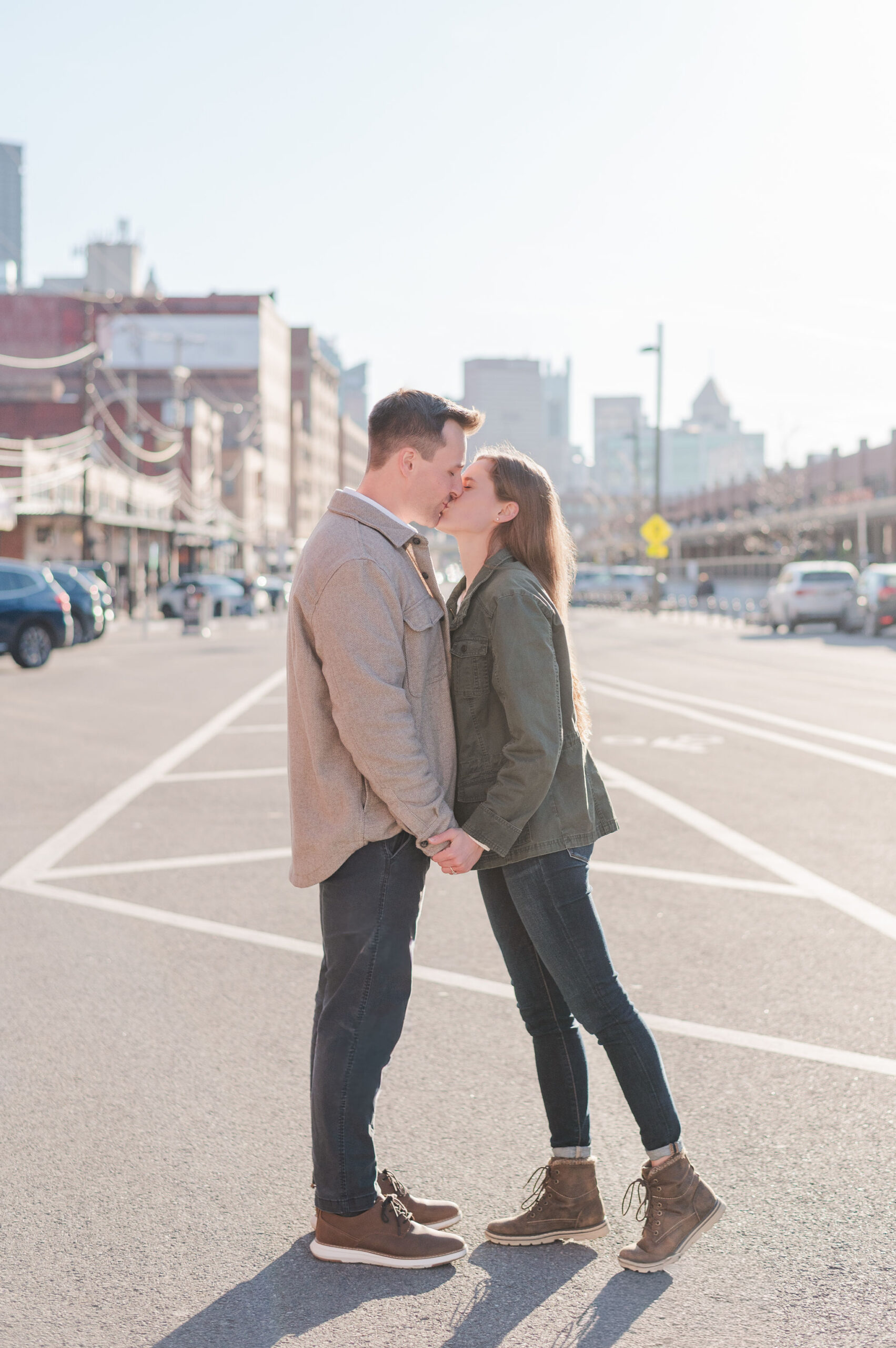 Couple kissing in the middle of the street for their Strip District engagement photos.