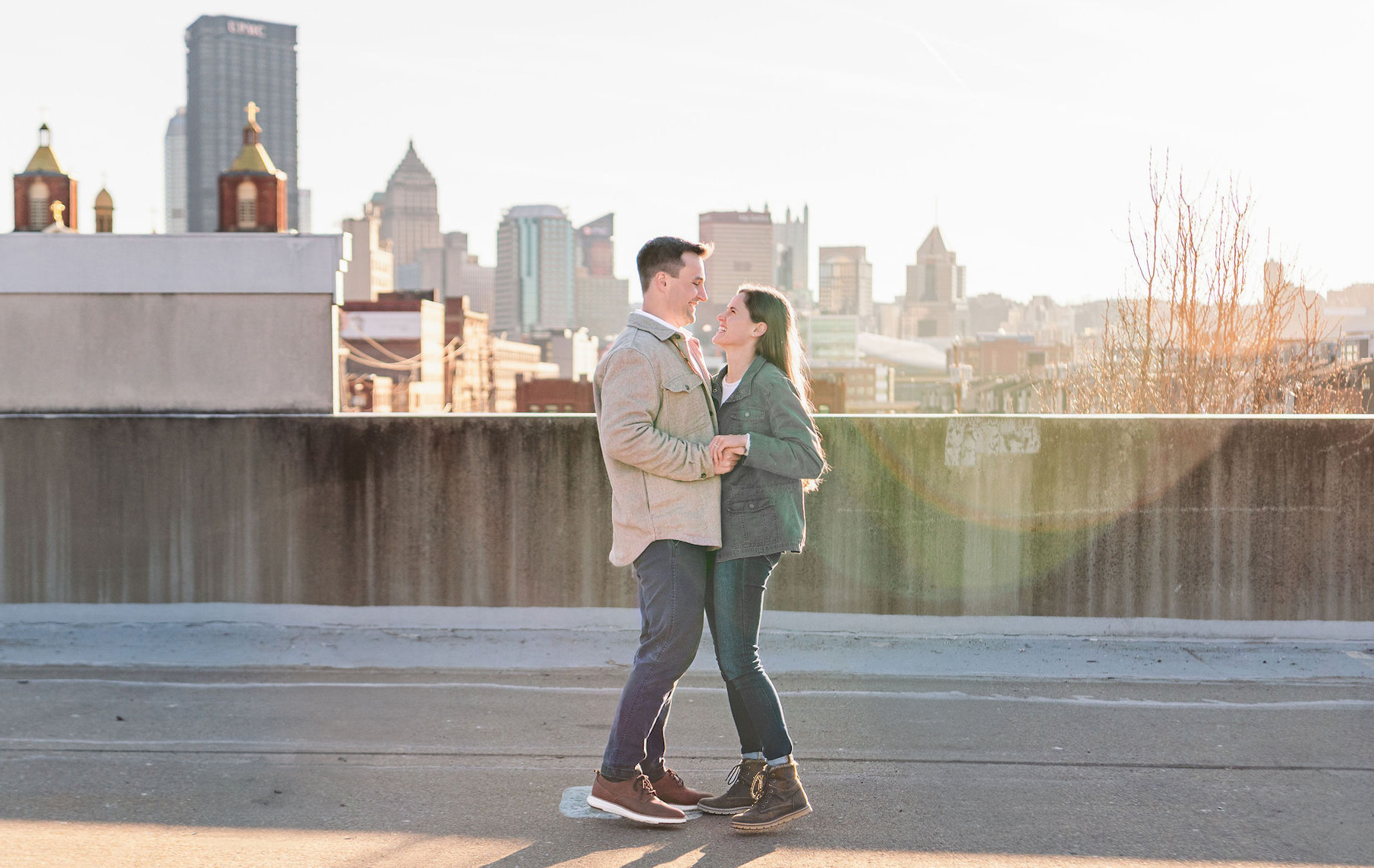 Couple standing together on a rooftop overlooking the Pittsburgh skyline