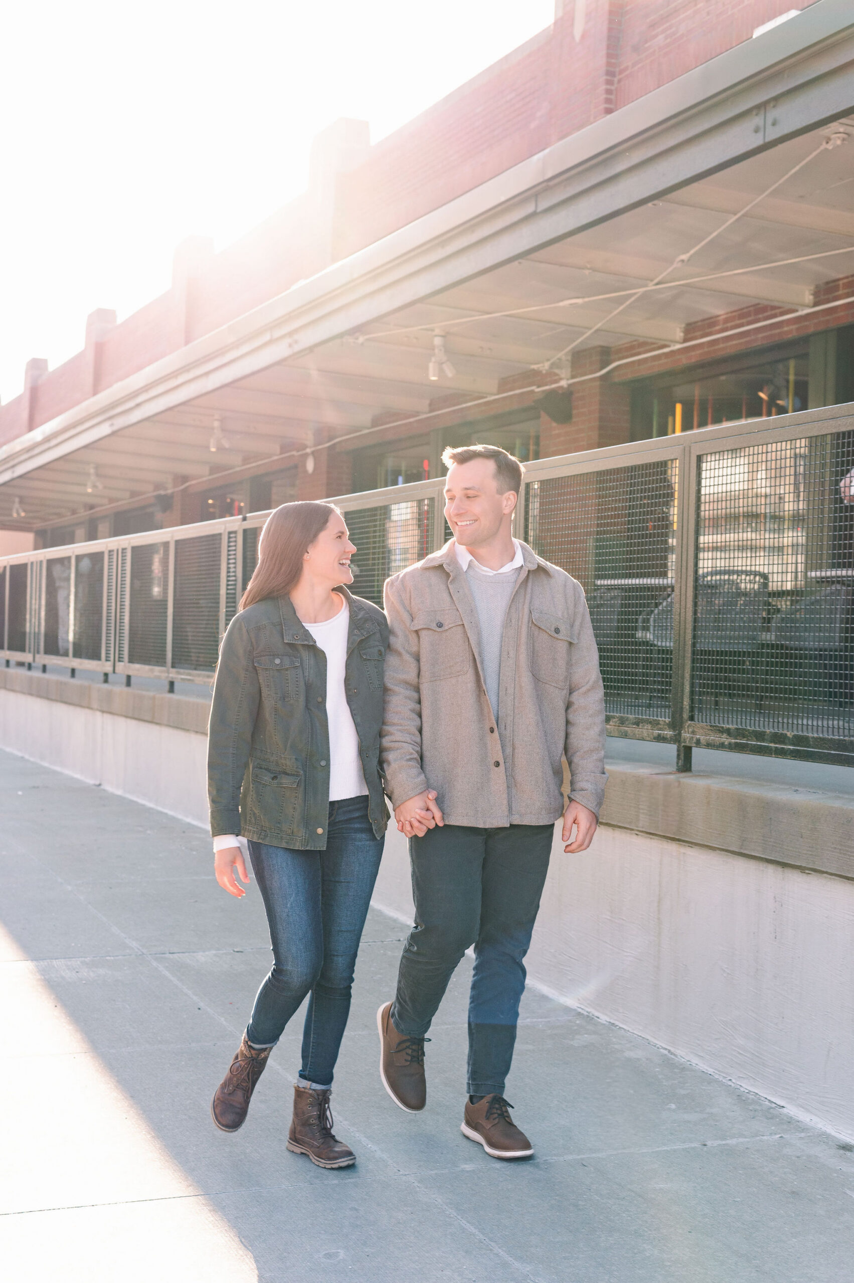 Couple walking past buildings in the Strip District.
